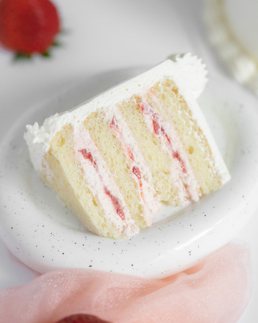 A slice of Strawberry Cake made of Vanilla Sponge Cake, Strawberry Fresh Cream, Fresh Strawberries & Chantilly Cream
